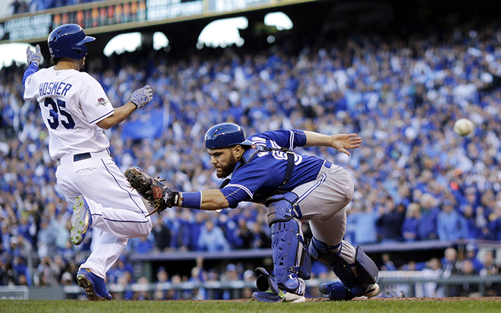 Toronto Blue Jays catcher Russell Martin misses the throw to home plate as Kansas City Royals&#039 Eric Hosmer right comes in to score during the seventh inning in Game 2 of baseball's American League Championship Series Saturday Oct. 17 2015