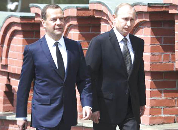 Russian President Vladimir Putin and Prime Minister Dmitry Medvedev walk to attend a wreath-laying ceremony at the Tomb of the Unknown Soldier in central Moscow Russia