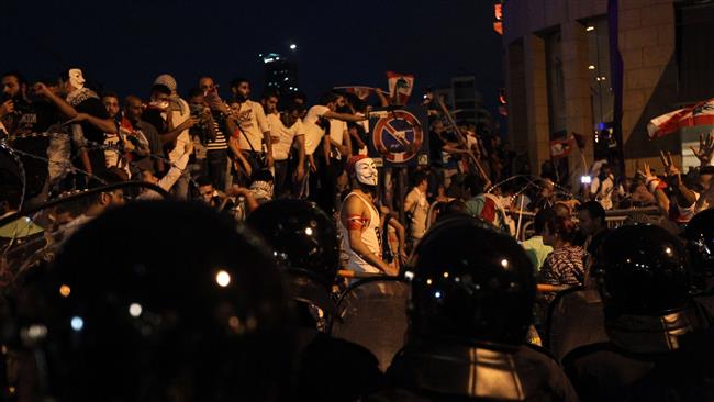 Lebanese protesters chant slogans in front of security forces during a demonstration over the garbage crisis in the capital Beirut