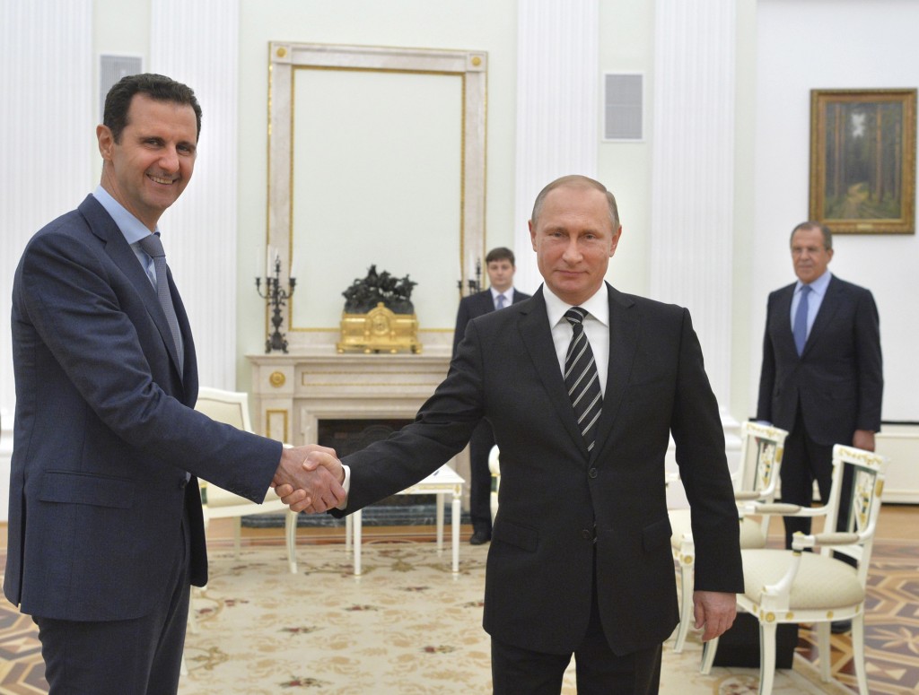 Russian President Putin shakes hands with Syrian President Assad during a meeting at the Kremlin in Moscow