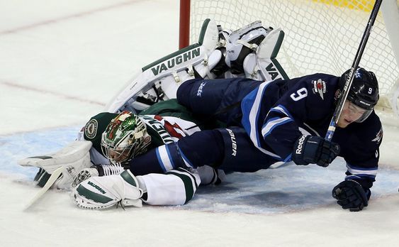 Copp gets tangled up with Minnesota Wild goaltender Darcy Kuemper during first period NHL hockey action in Winnipeg Sunday Oct. 25 2015