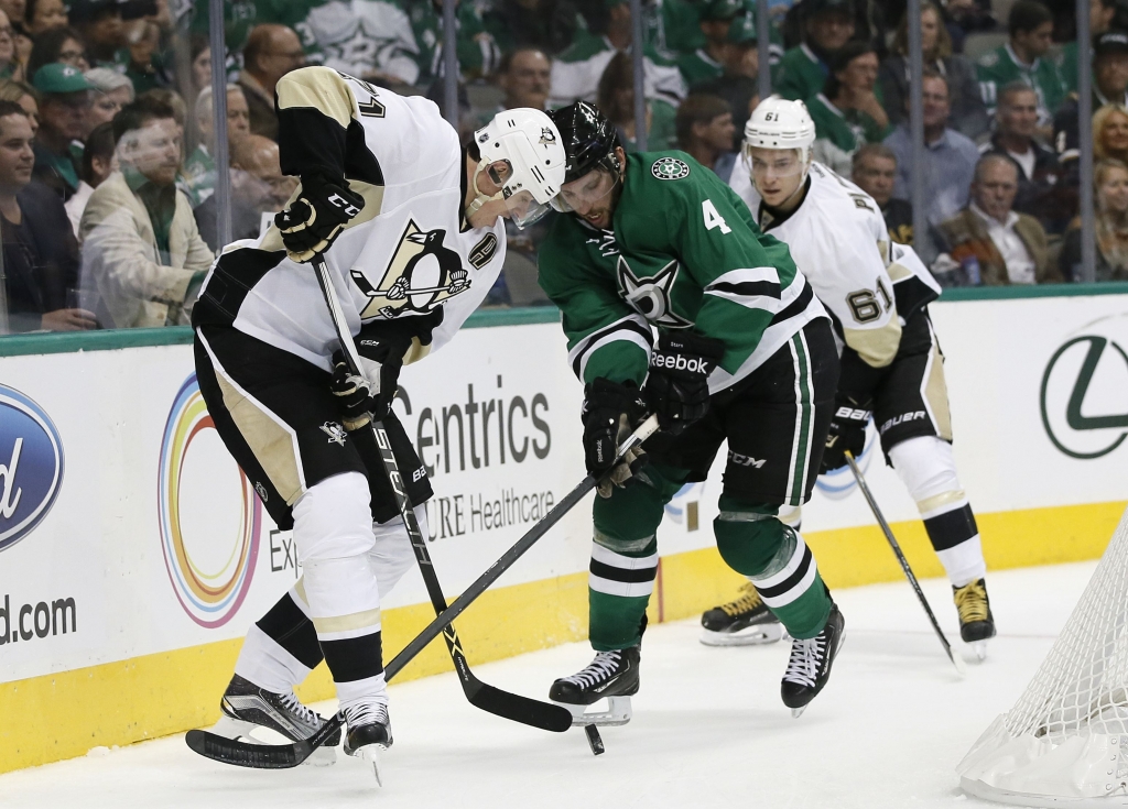 Penguins Stars Hockey Penguins&#39 Evgeni Malkin attempts to gain control of the puck against Dallas Stars&#39 Jason Demers as Penguins&#39 Sergei Plotnikov watches in the second period