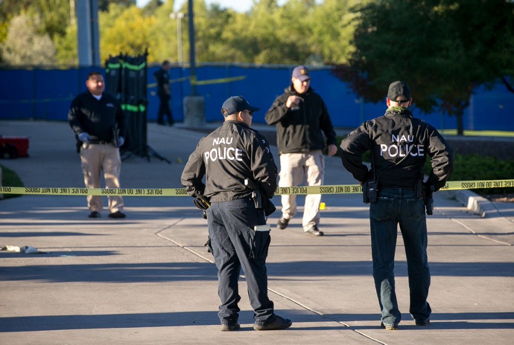 Police officers investigate a shooting at Northern Arizona University campus in Flagstaff Ariz. Friday Oct. 9 2015