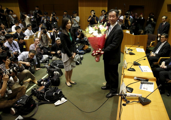 Takaaki Kajita receives flowers from his university after winning the Nobel Prize with Mac Donald for his work on neutrinos.    Reuters