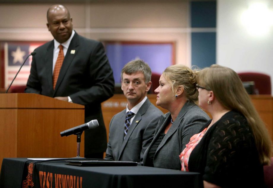 Katy super-intendent Alton Frailey standing and other school officials discuss a junior high student's complaint that an assignment was aimed at questioning the existence of God