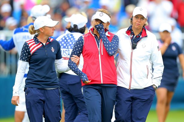 Alison Lee of the United States is comforted by Wendy Ward United States assistant captain and Stacy Lewis on the 18th green after Lee's error in picking up her ball on the 17th hole