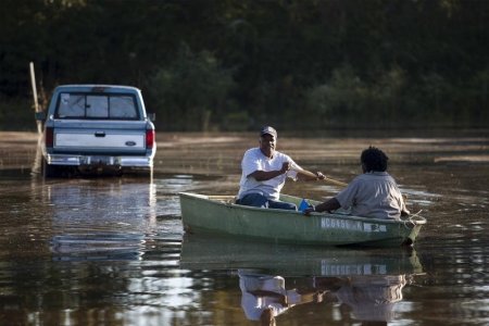 Arthur Linden brings his wife Betty to higher ground outside their flooded home along Dunbar Road in Georgetown South Carolina