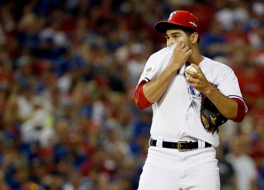 Texas Rangers starting pitcher Martin Perez pauses between pitches against the Toronto Blue Jays during the fourth inning in Game 3 of baseball's American League Division Series Sunday Oct. 11 2015 in Arlington Texas