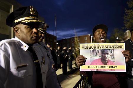 A demonstrator holds a sign in front of the Baltimore Police Department Western District station during a protest against the death in police custody of Freddie Gray in Baltimore