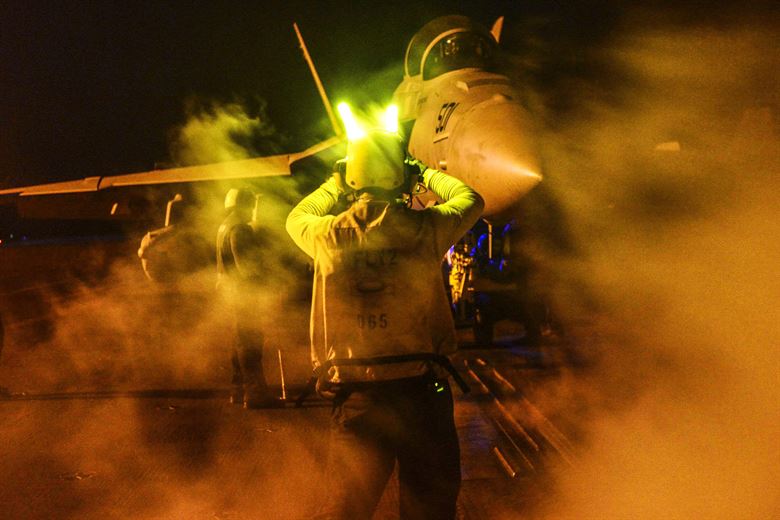 A U.S. Navy seaman directs an E  A-18G Growler to the catapult on the flight deck of the aircraft carrier USS Theodore Roosevelt in the U.S. 5th fleet area of operations