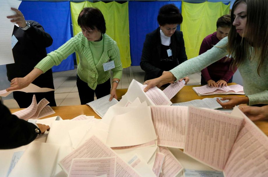 Members of a local election commission count ballots at a polling station in Kiev Ukraine Sunday Oct. 25 2015