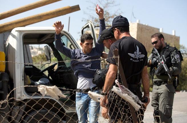 Israeli border policemen check a Palestinian driver on a road outside the Palestinian neighborhood of Jabal Mukaber in East Jerusalem