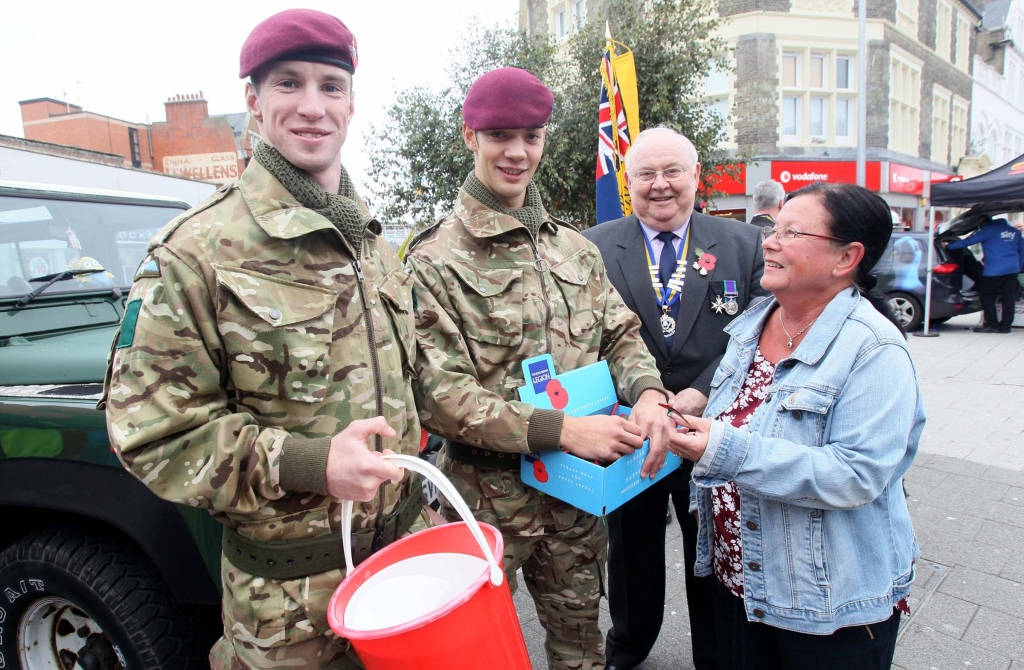 Audrey Anderson gets her poppy in Clacton town centre from Private Elias Dexter and GDSM Reece Cilia both from 3 Para as Essex RBL president Malcolm Radcliffe looks