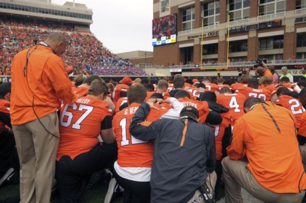 Oklahoma State players and staff form a prayer