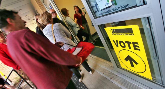 A pizza is delivered to the Gladstone North Professional Centre on Almon Street as people wait in a long lineup at an advanced polling station on Monday