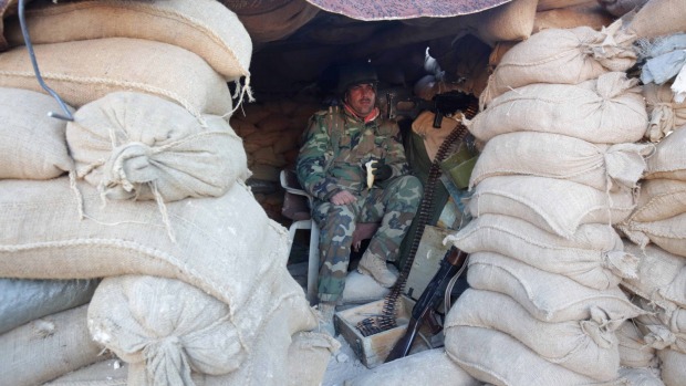 A Kurdish peshmerga fighter pauses during an operation in northern Syria