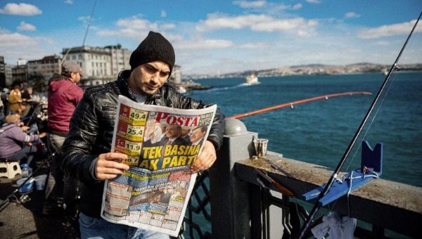 A fisher reads a newspaper in Istanbul on Nov. 2 2015 a day after Turkey