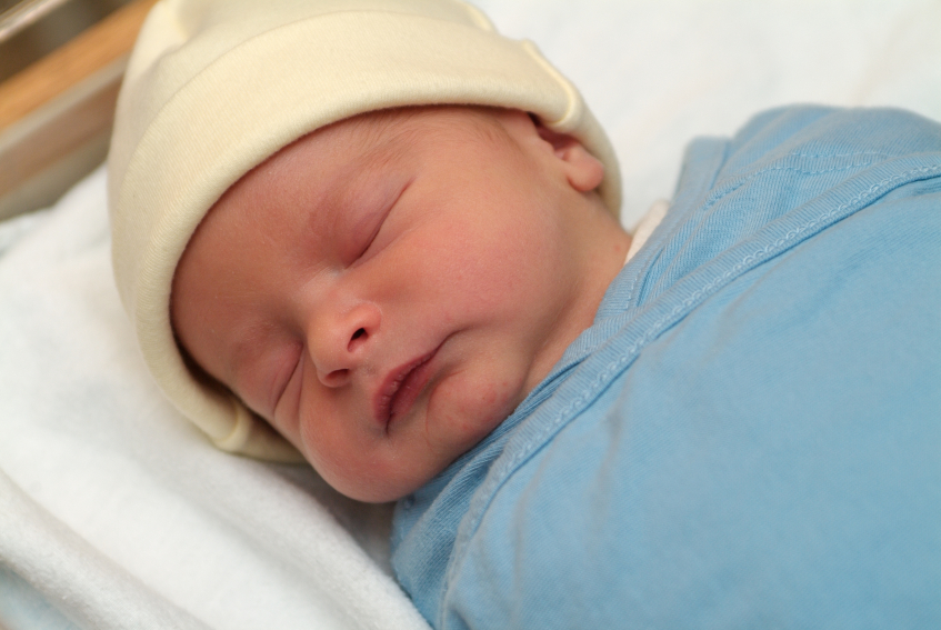 A swaddled newborn baby is sleeping