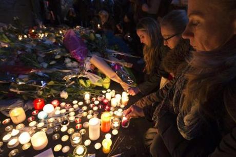 People lit candles Saturday at a makeshift memorial on the Rue de Charonne in Paris to the victims of the attacks