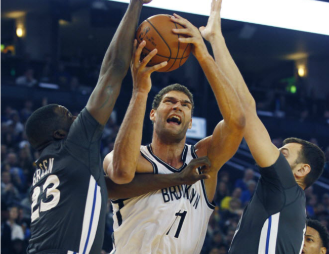 Nets&#39 Brook Lopez center goes up between Golden State Warriors&#39 Draymond Green left and Andrew Bogut during the first half