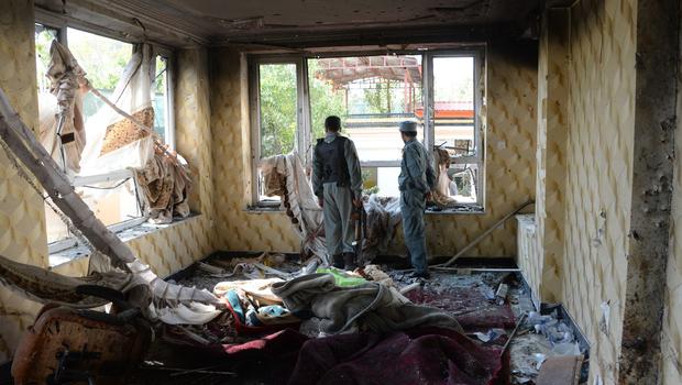 Afghan security personnel inspect a damaged building after a Taliban attack in Kabul