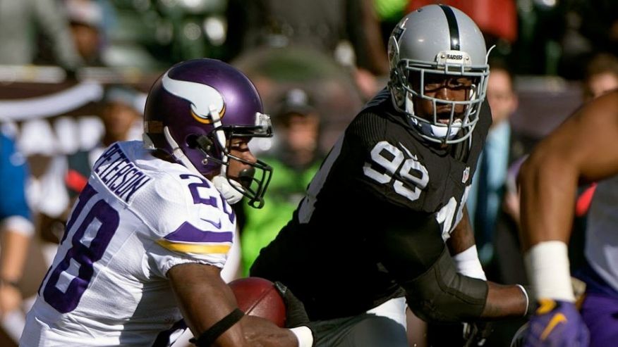 Oakland CA USA Minnesota Vikings running back Adrian Peterson runs with the football against Oakland Raiders outside linebacker Aldon Smith during the first quarter