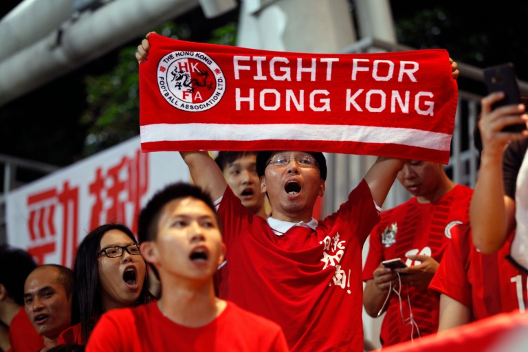 AFP  File  Isaac Lawrence Hong Kong football fans cheer for their team during the World Cup qualifier against China at Hong Kong's Mong Kok Stadium