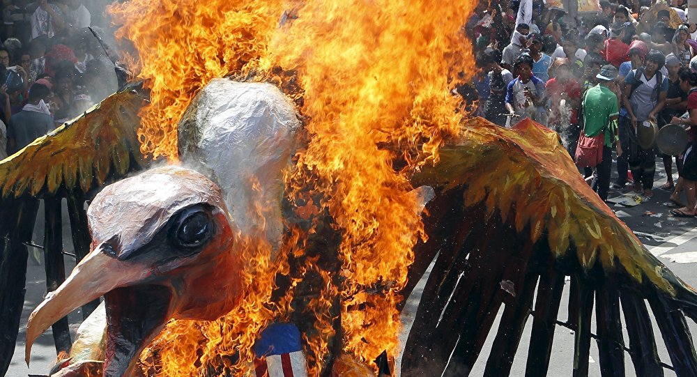 Protesters burn an effigy during a rally near the venue of the Asia Pacific Economic Cooperation summit in Manila