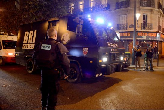 Policemen patrol the streets during gunfire near the Bataclan concert hall