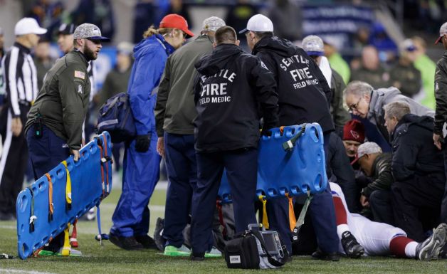 Backboards are brought in to take injured Arizona Cardinals guard Mike Iupati off the field after a play against the Seattle Seahawks during the first half of an NFL football game Sunday Nov. 15 2015 in Seattle
