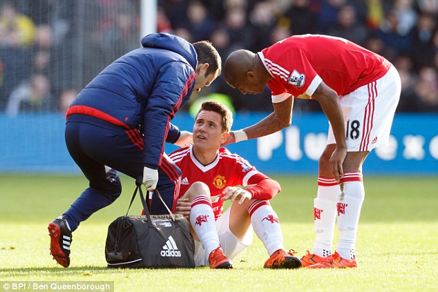 Ashley Young checks on his team-mate as medical staff treat the Spain midfielder at Vicarage Road