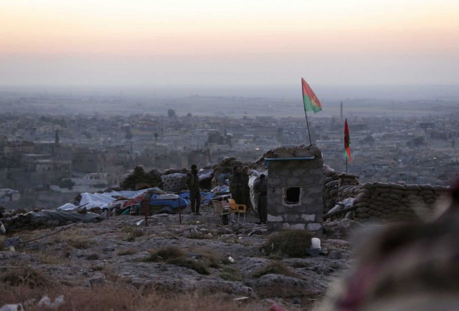 Kurdish fighters watch in the early morning as they fight against the Islamic State group in Sinjar Iraq Friday Nov. 13 2015. Officials with the Iraqi Kurdish militia said they are preparing to push their large-scale military operation into the center