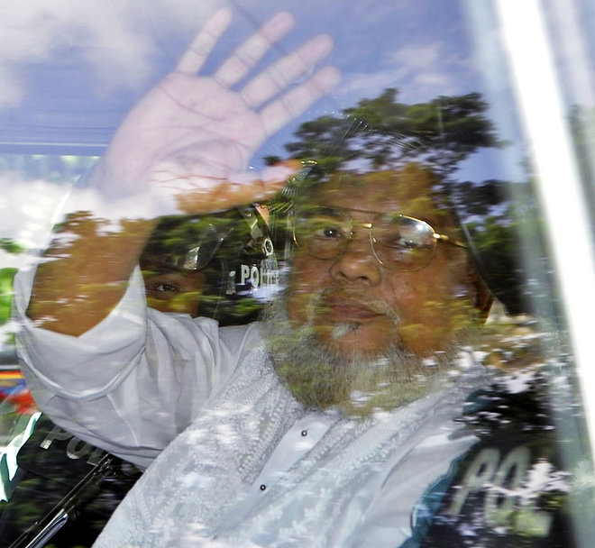 Jamaat-e Islami Secretary General Ali Ahsan Mohammad Mujahid waves from a police vehicle as he is brought to court in Dhaka Bangladesh. Senior Jail Superintendent Mohammad Jahangir Kabir told The Associated Press