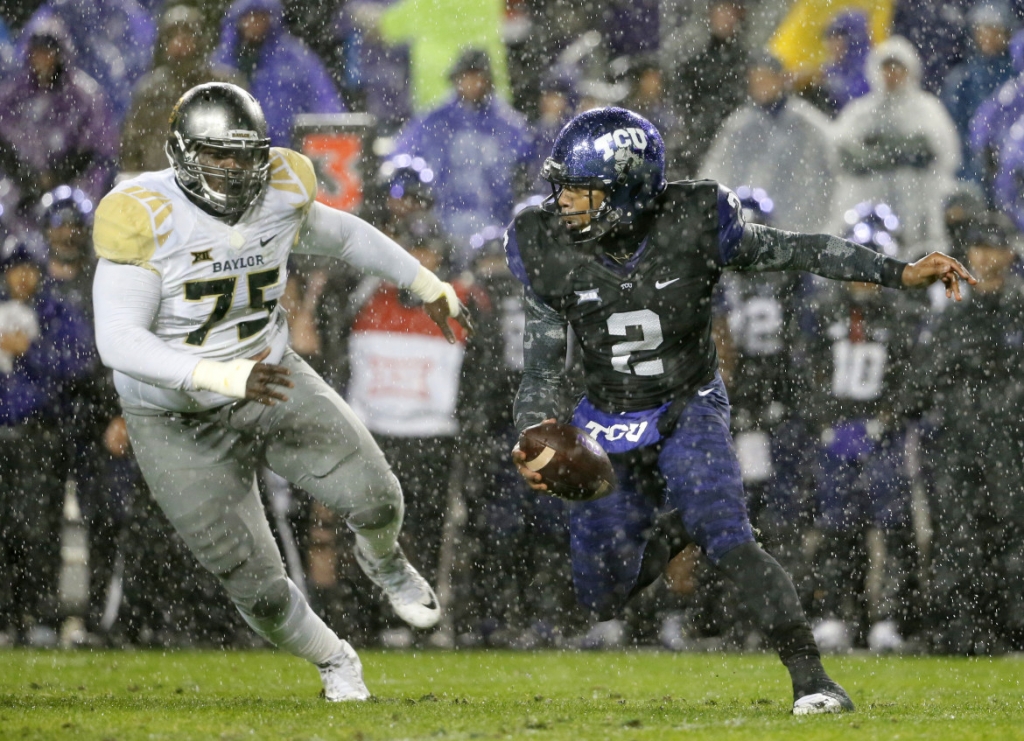 TCU quarterback Trevone Boykin scrambles out of the pocket under pressure from Baylor defensive tackle Andrew Billings in the first half of an NCAA college football game Friday Nov. 27 2015 in Fort Worth Texas