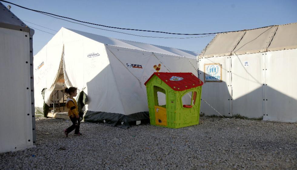 Associated Press A girl walks to a children's lodge set among tents in the transit center for refugees near the village of Tabanovce Thursday in northern Macedonia on the border with Serbia