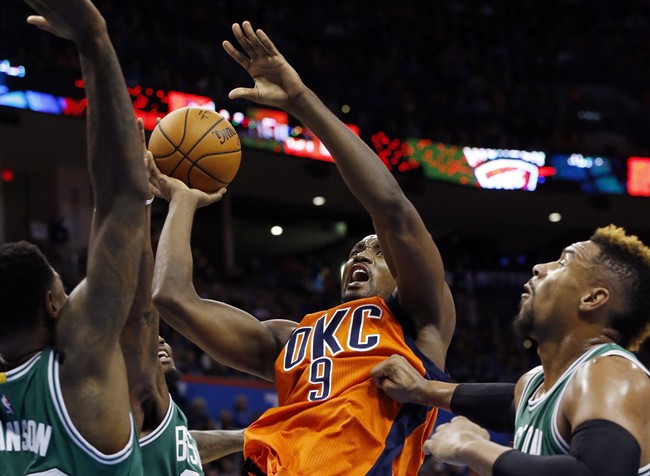 Oklahoma City Thunder forward Serge Ibaka shoots between Boston Celtics Amir Johnson left Jae Crowder center and Jared Sullinger right in the second quarter of an NBA basketball game in Oklahoma City Sunday Nov. 15 2015. (AP