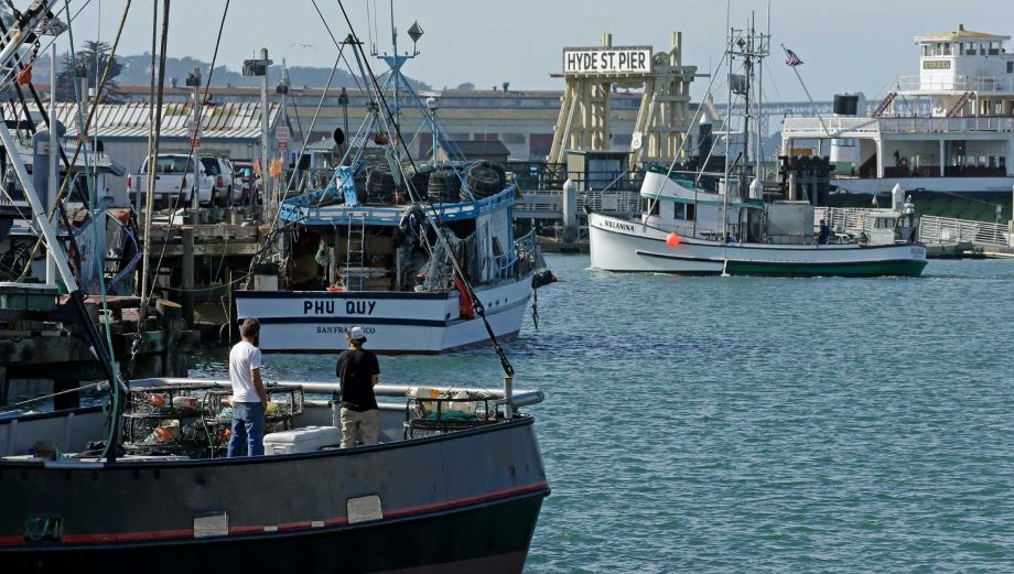 Fishermen stand on a boat loaded with crab pots left Thursday Nov. 5 2015 at Fisherman's Wharf in San Francisco. Wildlife authorities delayed the Dungeness crab season and closed the rock crab fishery for most of California on Thursday just days aft