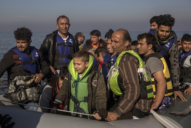 Refugees and migrants arrive safely to a beach after crossing the Aegean Sea on a dinghy from the Turkish coast to the northeastern Greek island of Lesbos on Friday Nov. 20 2015. Most nations along Europe's refugee corridor except Greece abruptly shut