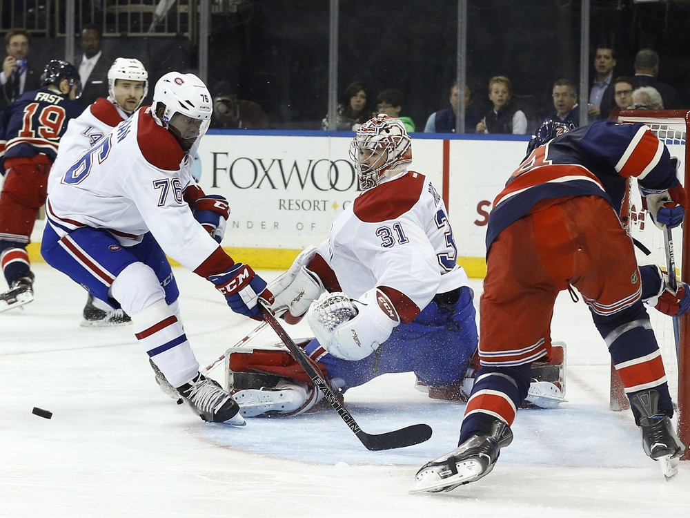 Montreal Canadiens goalie Carey Price blocks a shot attempt by New York Rangers center Oscar Lindberg as Canadiens defenseman P.K. Subban looks for the rebound during the second period of an NHL hockey game Wednesday Nov. 25 2015 in New