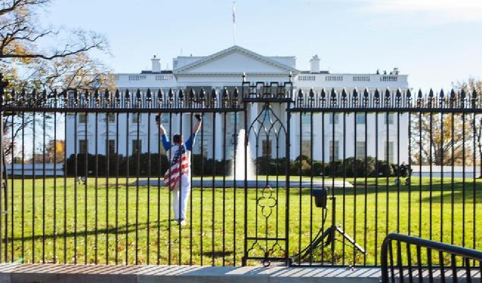 Caption +                   A man draped in an American flag jumped over the White House fence Thursday