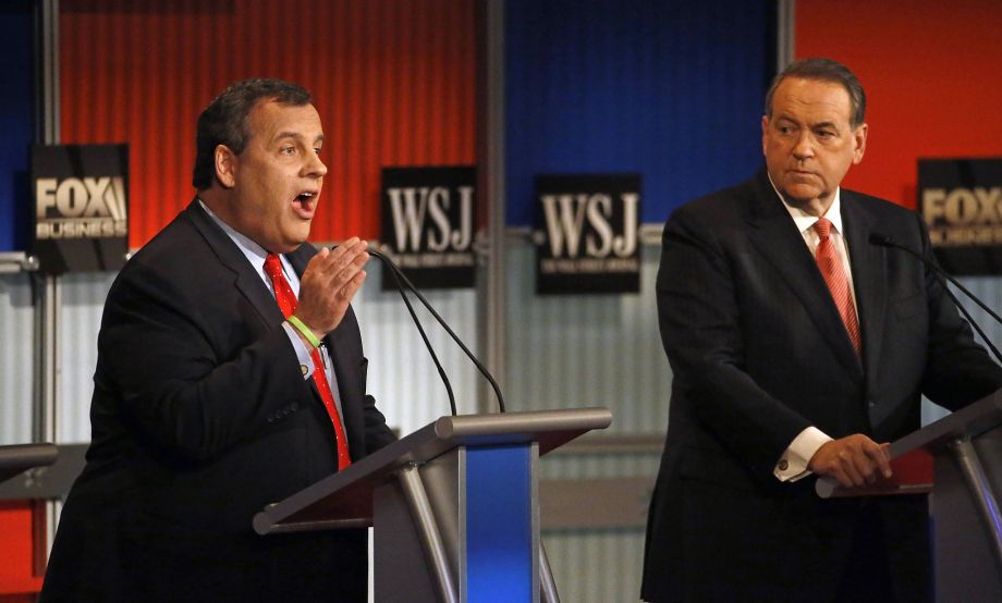 Mike Huckabee listens as Gov. Chris Christie makes a point during the first of the two GOP debates. Both men were dropped to the second-tier debate because of low poll numbers