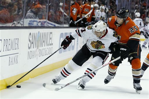 Chicago Blackhawks right wing Marian Hossa left battles for control of the puck against Anaheim Ducks center Mike Santorelli in the first period of an NHL hockey game in Anaheim Calif. Friday Nov. 27 2015