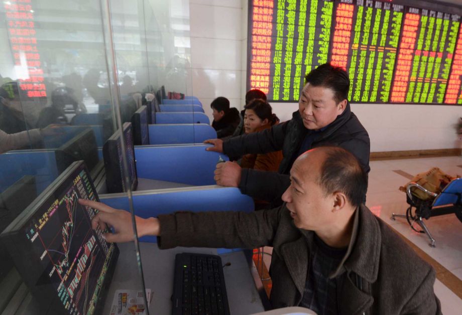 Chinese investors check stock prices on computer terminals at a brokerage house in Fuyang in central China's Anhui province Friday Nov. 27 2015. China's stock market fell sharply Friday as investigations into the securities industry widened to include