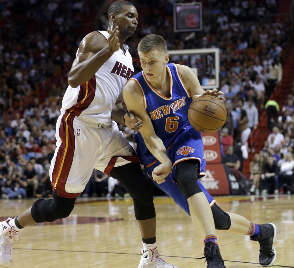 Knicks forward Kristaps Porzingis drives around Heat forward Chris Bosh during their game Monday in Miami. Bosh scored 16 points and Miami won 95-78