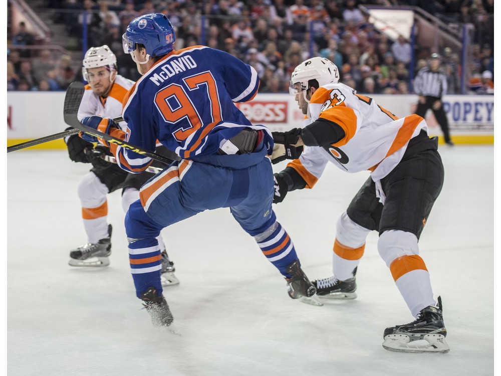 EDMONTON AB. NOVEMBER 3 2015-Connor Mc David of the Edmonton Oilers catches an edge with his left skate while being checked by Brandon Manning of the Philadelphia Flyers at Rexall Place in Edmonton. Mc David broke his collarbone in the fall and ensui