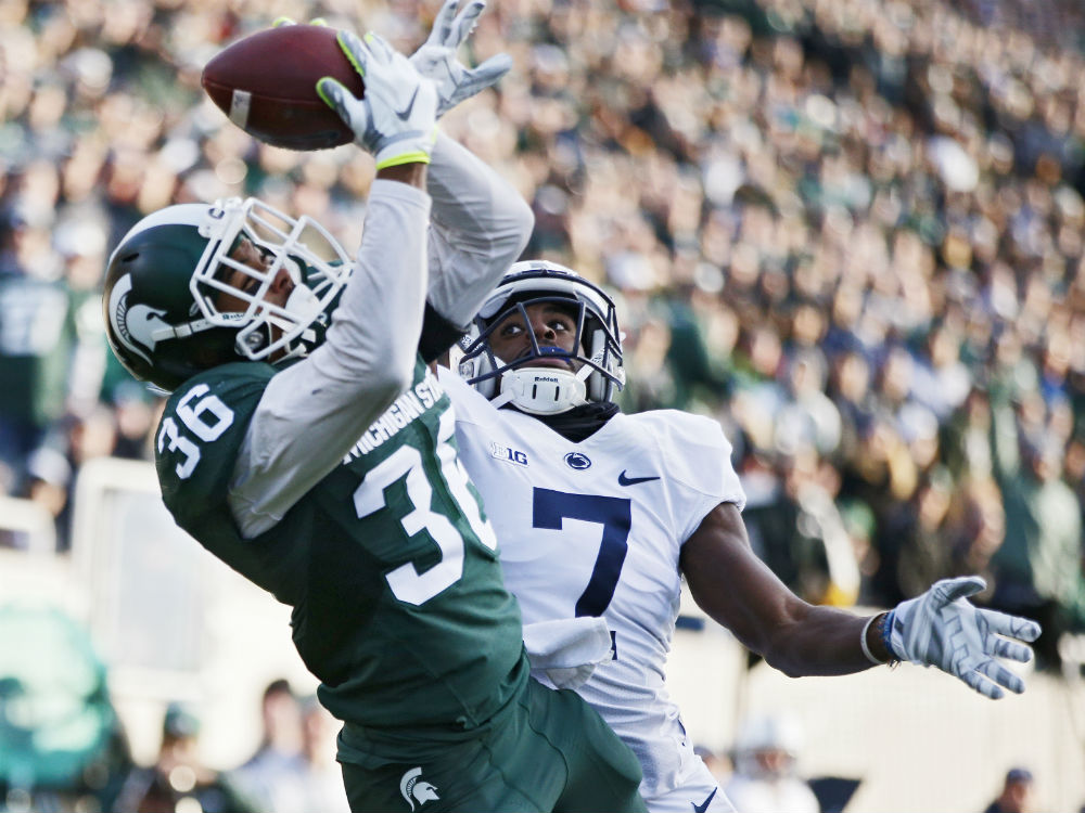 Windsor's Arjen Colquhoun #36 of the Michigan State Spartans makes an interception in the end zone of a pass intended for Geno Lewis #7 of the Penn State Nittany Lions in the first half of the game at Spartan Stadium