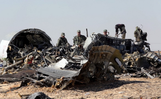 Military investigators from Russia stand near the debris of a Russian airliner at the site of its crash at the Hassana area in Arish city north Egypt on Nov. 1