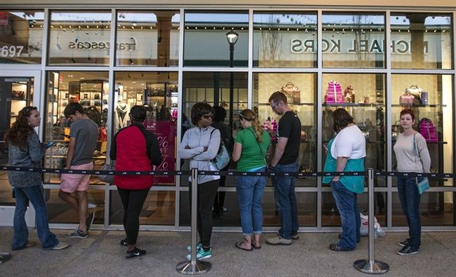 Shoppers line up in front of stores at Tanger Outlets in Pooler Thursday evening Nov. 26 2015 as they wait for the opening of the big sale day of Black Friday in Pooler Ga.  THE