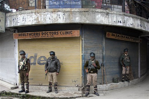 Indian paramilitary soldiers stand guard at a closed market area during restrictions in Srinagar Indian controlled Kashmir Saturday Nov. 7 2015. Thousands of government forces have fanned out across the Indian portion of Kashmir to provide a security