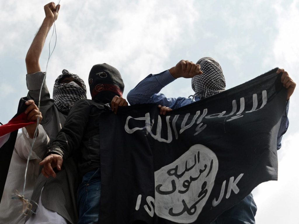 Demonstrators hold up an Isis flag